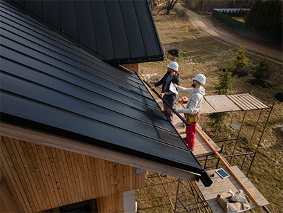 Full Shot Roofers Working  Togethe with Helmets